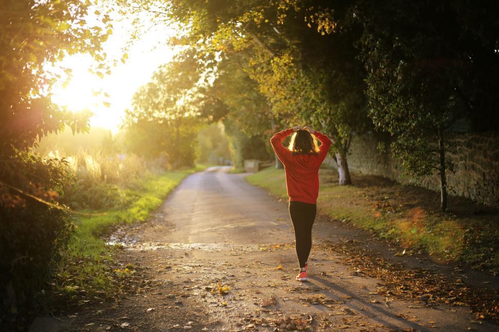 Free Image of Woman Walking Down Dirt Road 