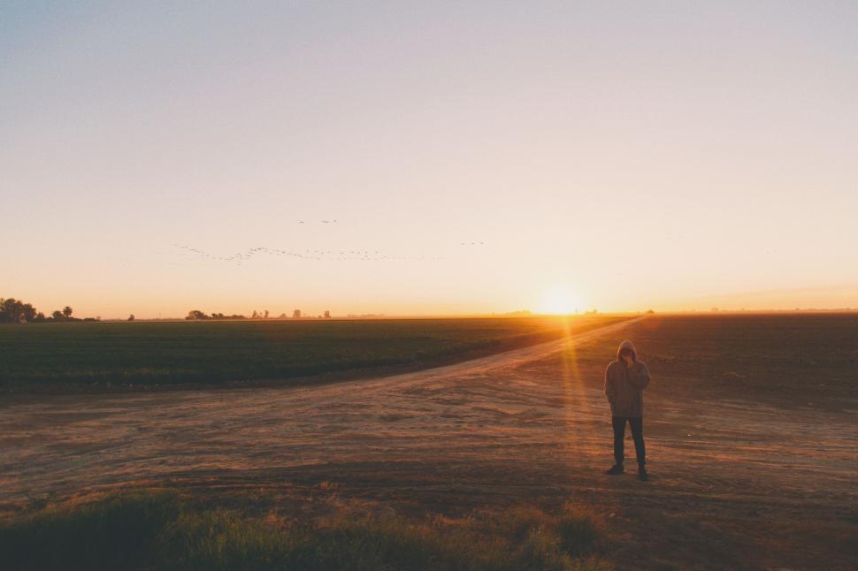 Free Image of Person Standing in Field at Sunset 
