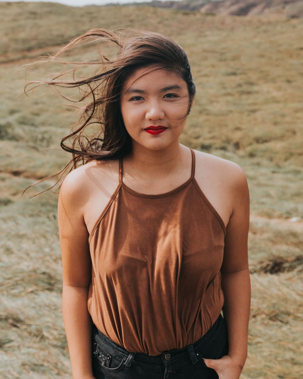 Free Stock Photo of Woman Stands in Field With Hair Blowing in Wind ...