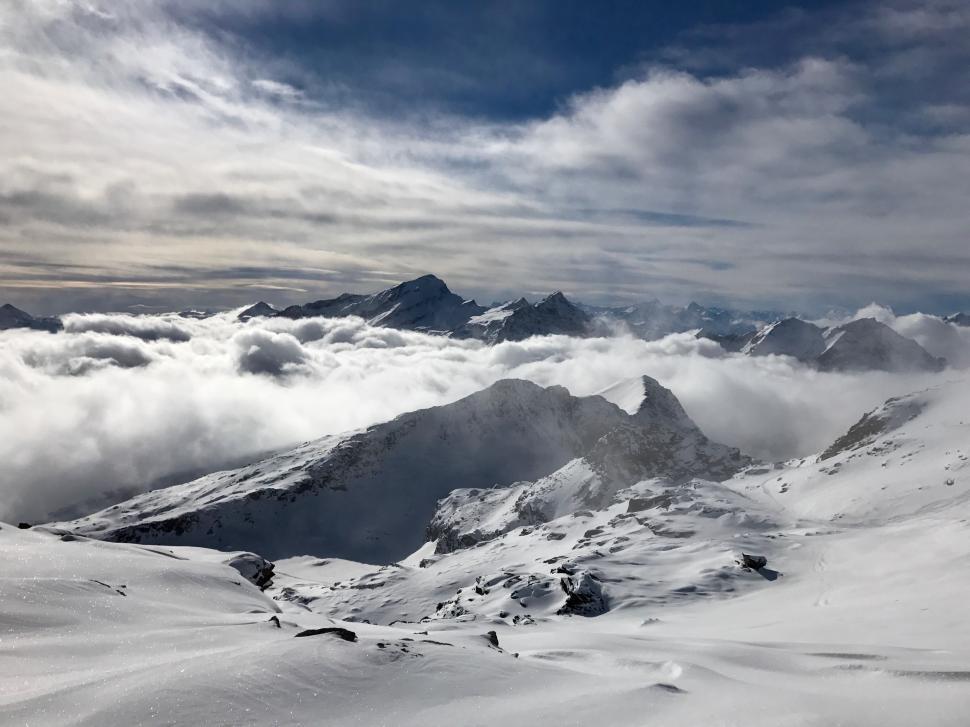 Free Image of Snow-Covered Mountain With Clouds in the Sky 