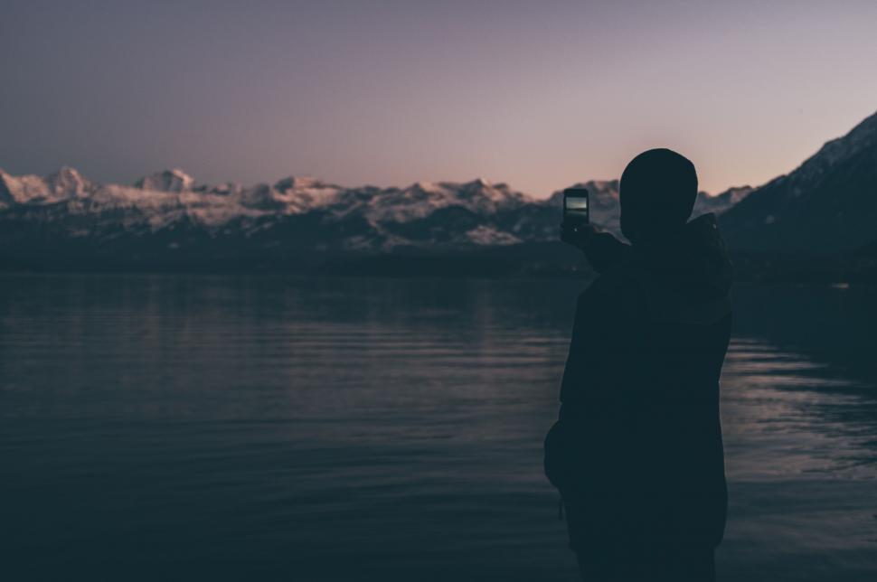 Free Image of Person Standing in Water Taking Picture With Cell Phone 