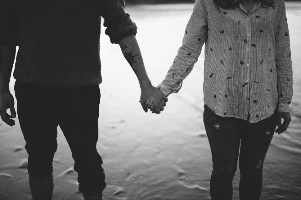 Free Image of Man and Woman Holding Hands Walking in the Snow 