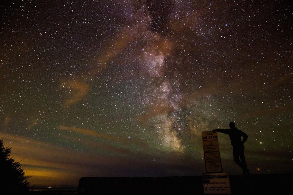 Free Image of Man Standing on Hill Under Star-Filled Night Sky 