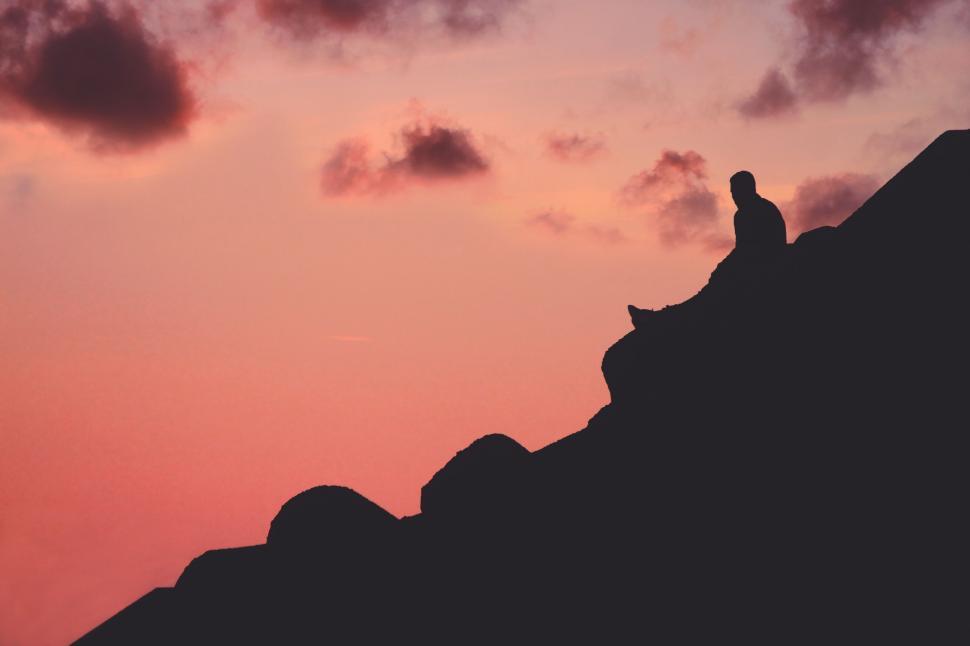 Free Image of Person Standing on Top of Mountain at Sunset 
