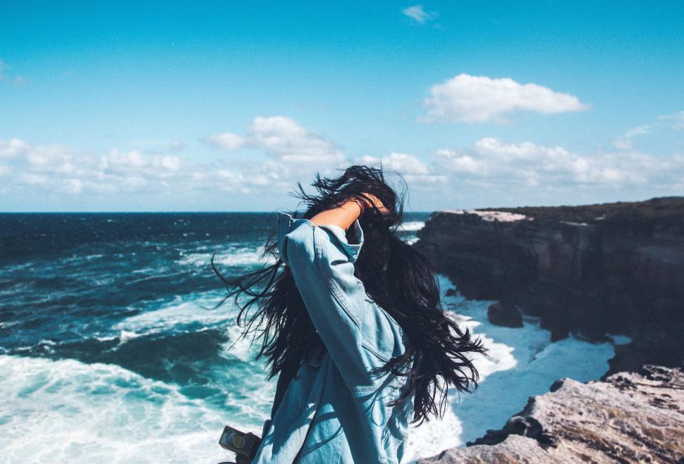 Free Image of Woman Standing on Cliff by Ocean 