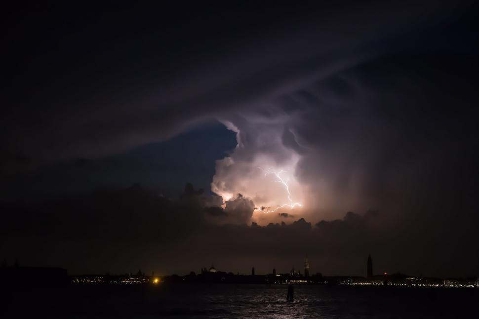 Free Image of Large Cloud Hovering Over Body of Water 