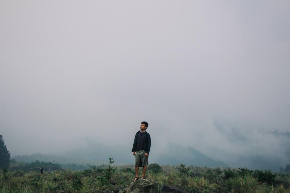 Free Image of Man Standing on Top of Lush Green Hillside 