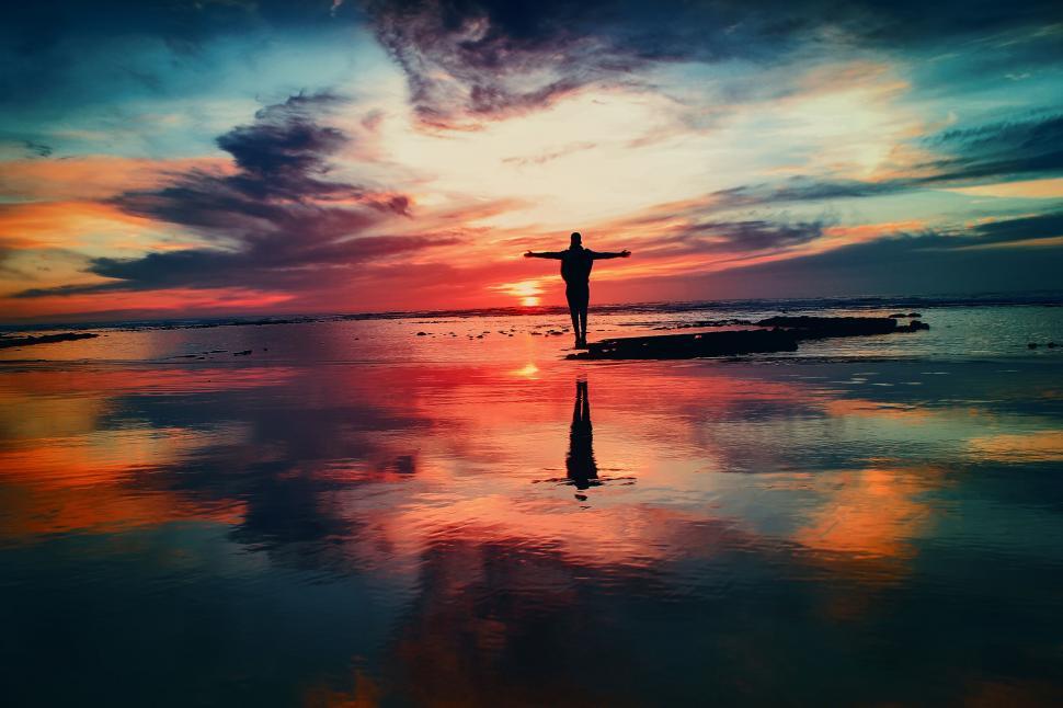 Free Image of Person Standing on Beach at Sunset 