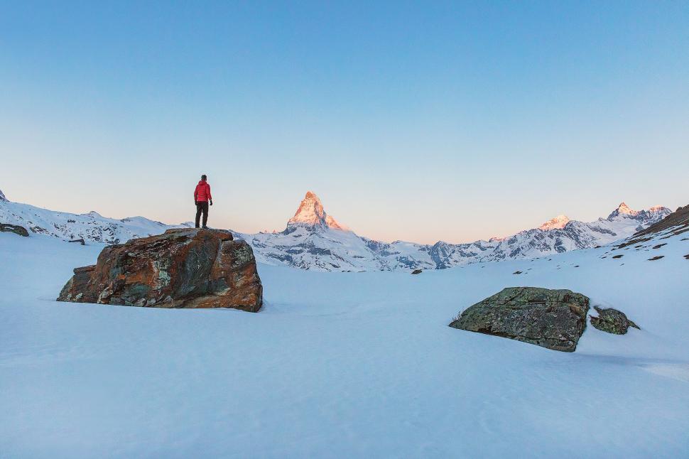 Free Image of Man Standing on Snow Covered Mountain Top 