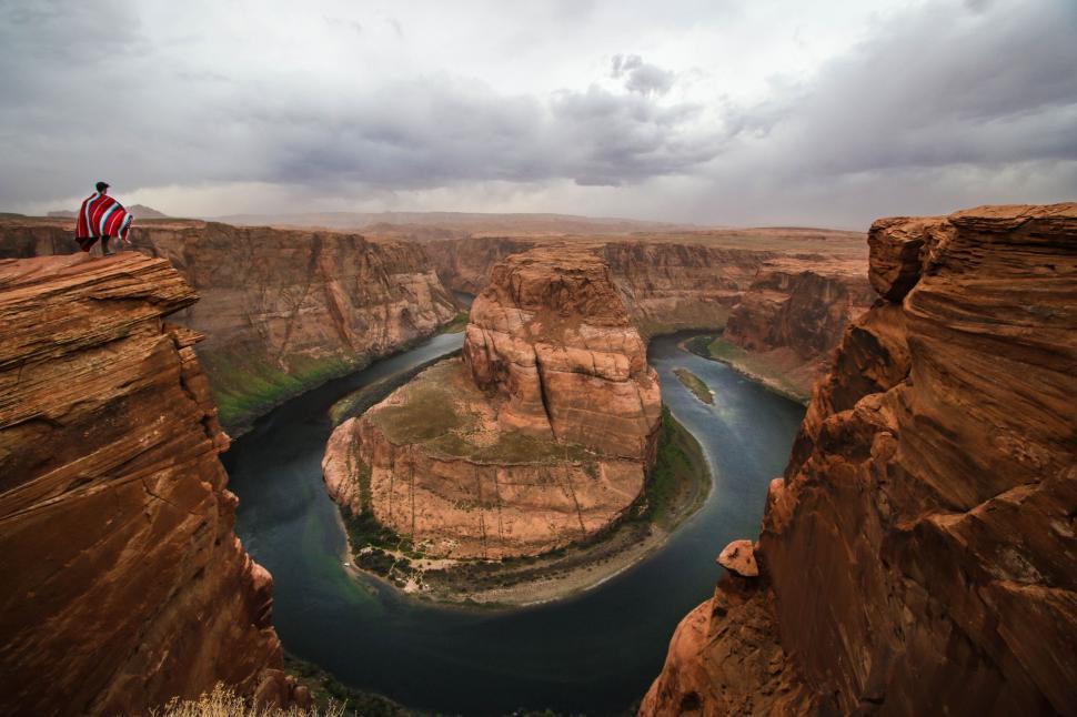 Free Image of Man Standing on Cliff Next to River 