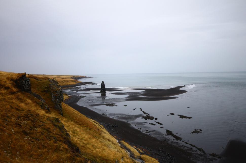 Free Image of Person Standing on Rocky Beach by Water 
