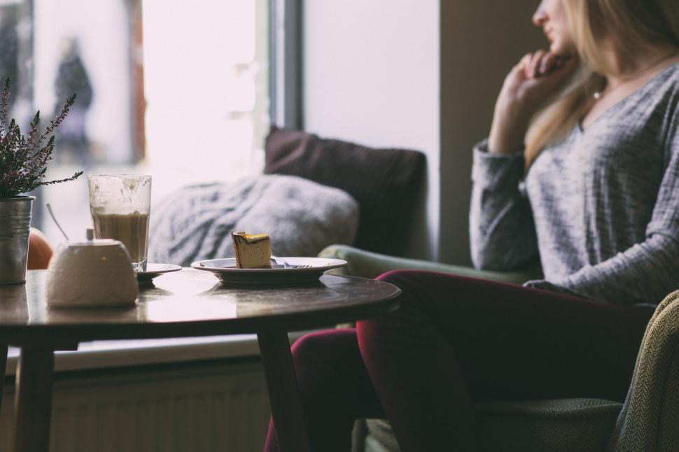 Free Image of Woman Sitting at Table in Front of Window 