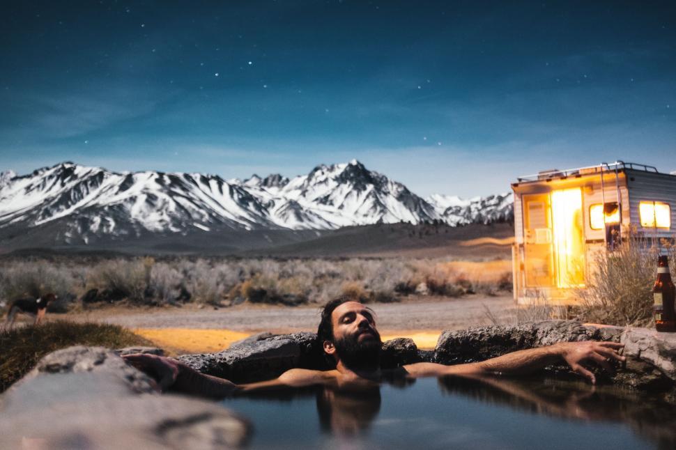Free Image of Man Laying on the Ground Next to a Body of Water 