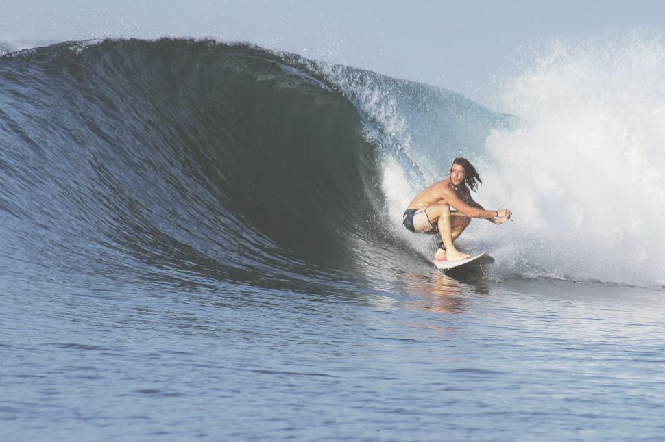 Free Image of Woman Riding a Wave on Top of a Surfboard 