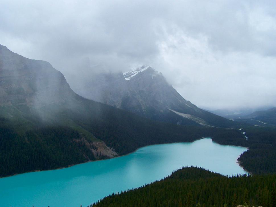 Free Stock Photo of Blue Lake Surrounded by Mountains Under a Cloudy ...