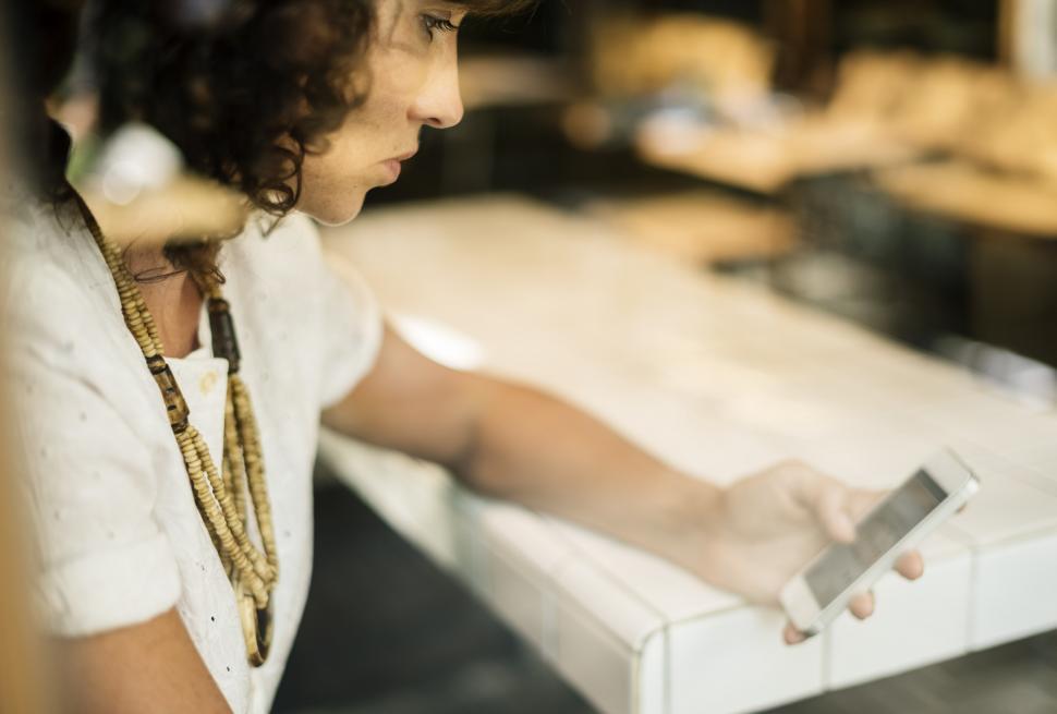 Free Image of Woman Checking Cell Phone in Store 