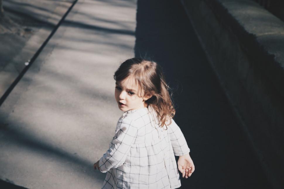 Free Image of Young Girl Walking Along Sidewalk 
