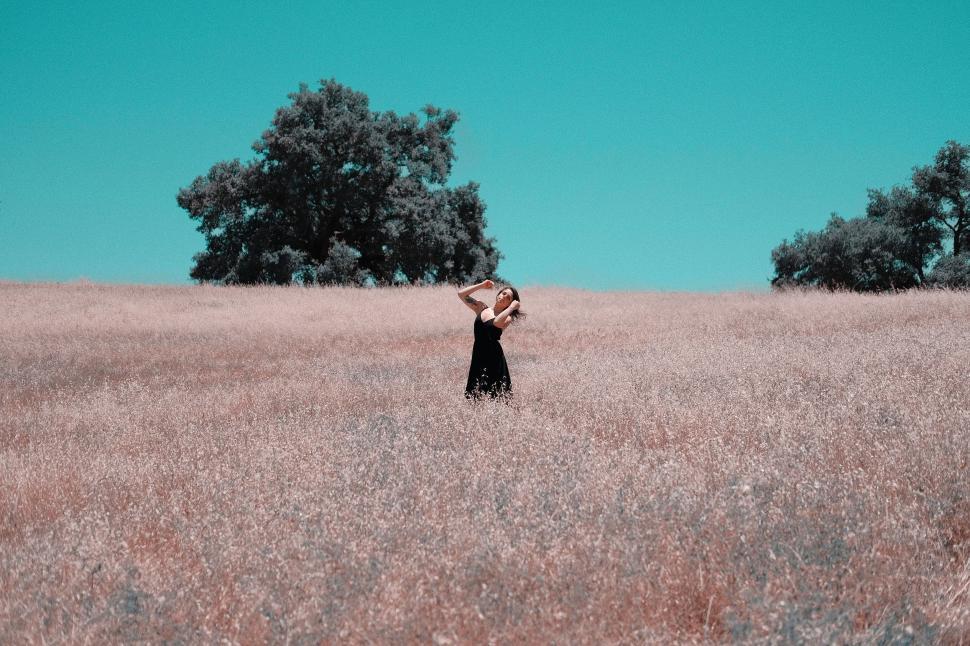 Free Image of Woman Standing in a Field of Tall Grass 