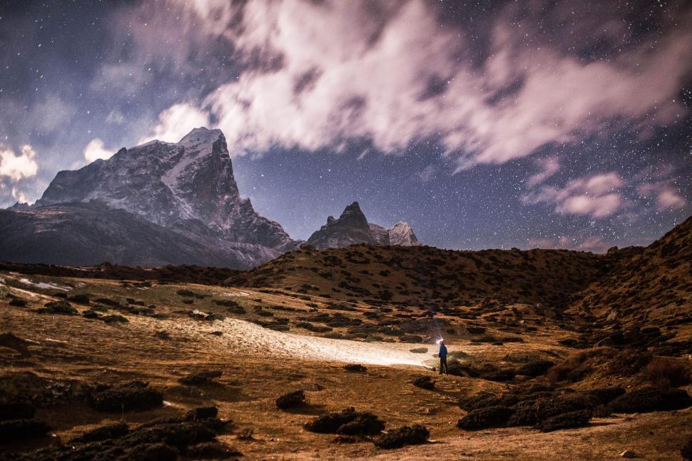 Free Image of Man Standing in Field With Mountains in Background 