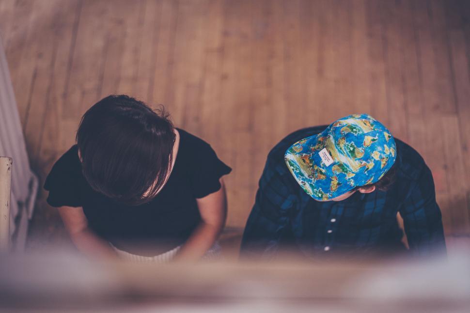 Free Image of Couple Sitting on Top of Wooden Floor 