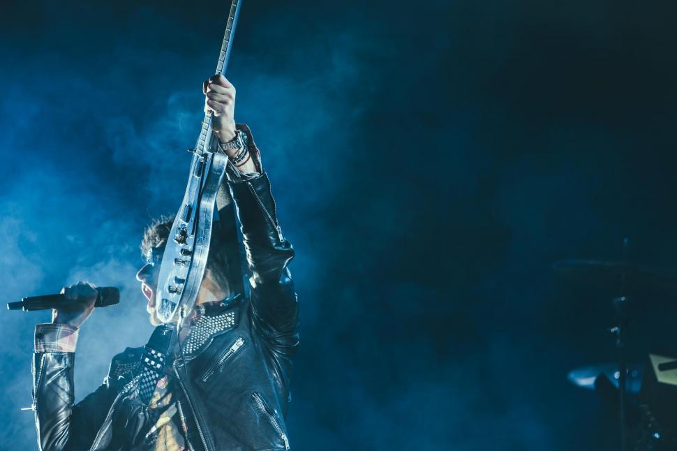 Free Image of Man Holding Microphone Up in the Air 