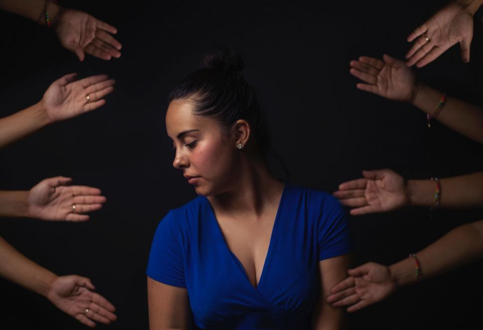 Free Image of Woman in Blue Dress Surrounded by Hands 