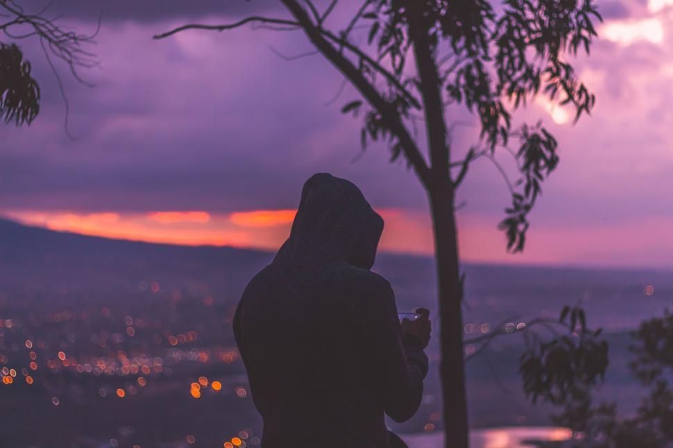 Free Image of Person Standing in Front of Tree at Sunset 