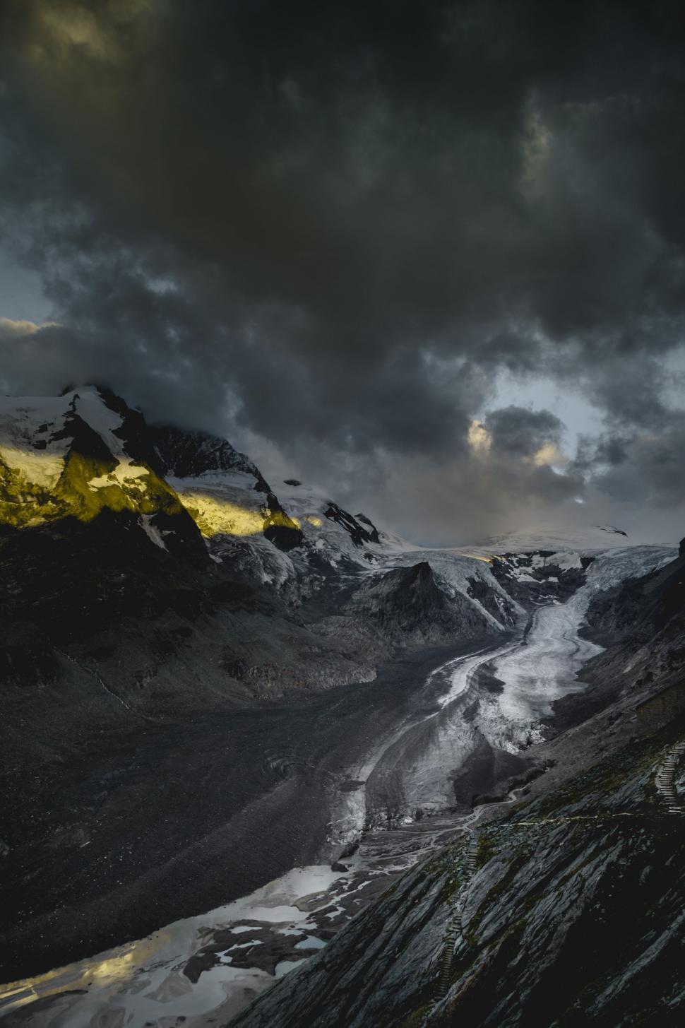 Free Image of Cloudy Sky Over Black and White Mountains 