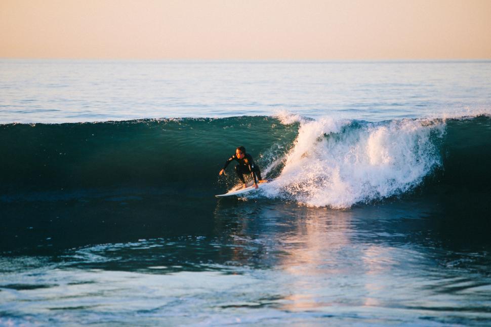 Free Image of Man Riding a Wave on Top of a Surfboard 