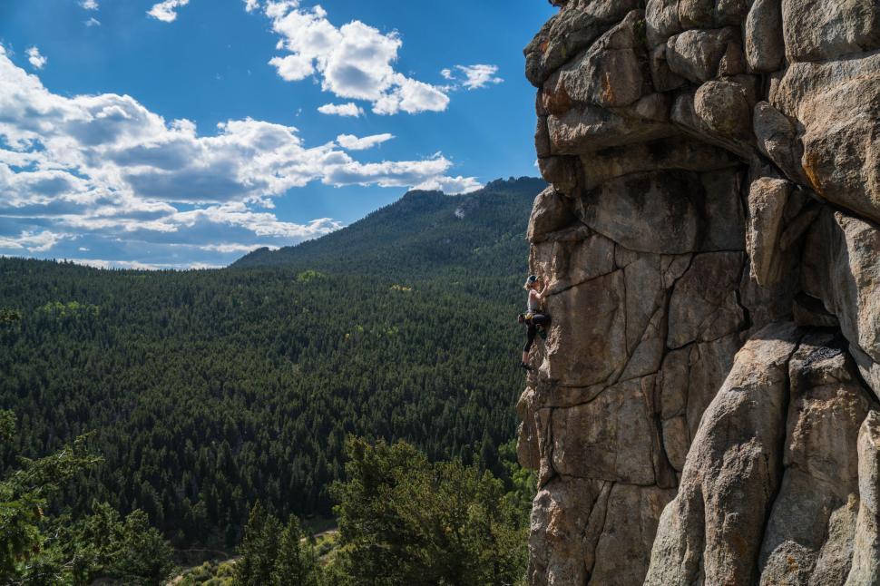 Free Image of Rocky Mountain With Trees and Mountains in Background 