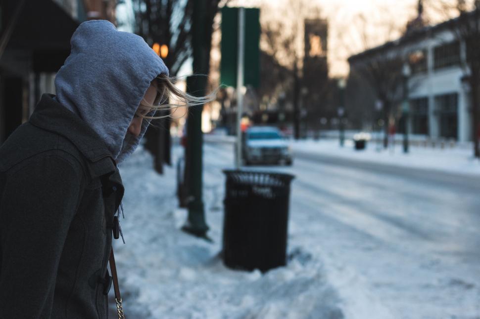 Free Image of Person in Hooded Jacket Walking on Snowy Street 