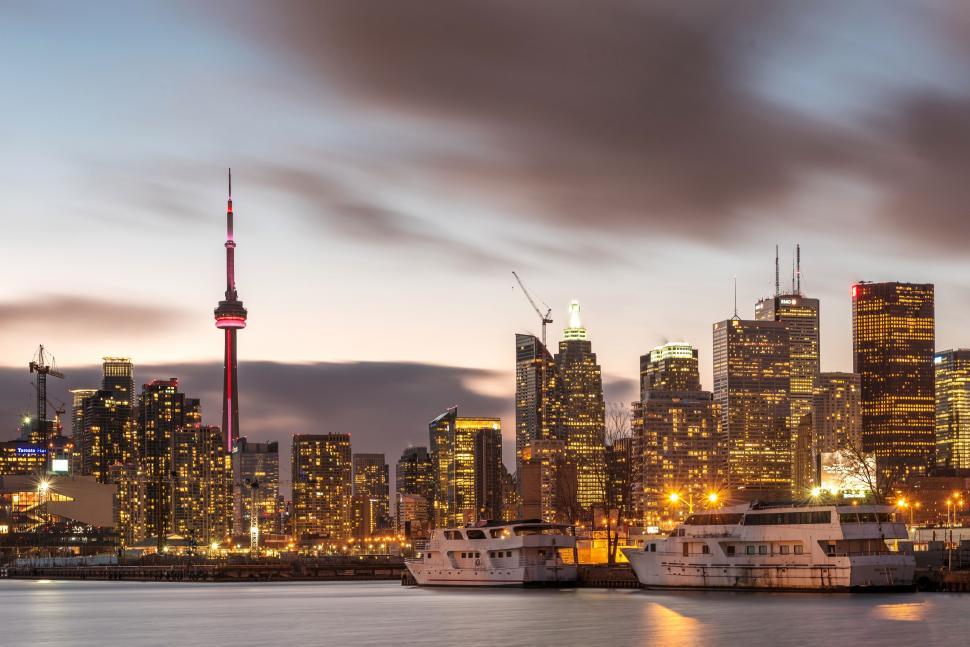 Free Image of City Skyline at Night With Boats in the Water 