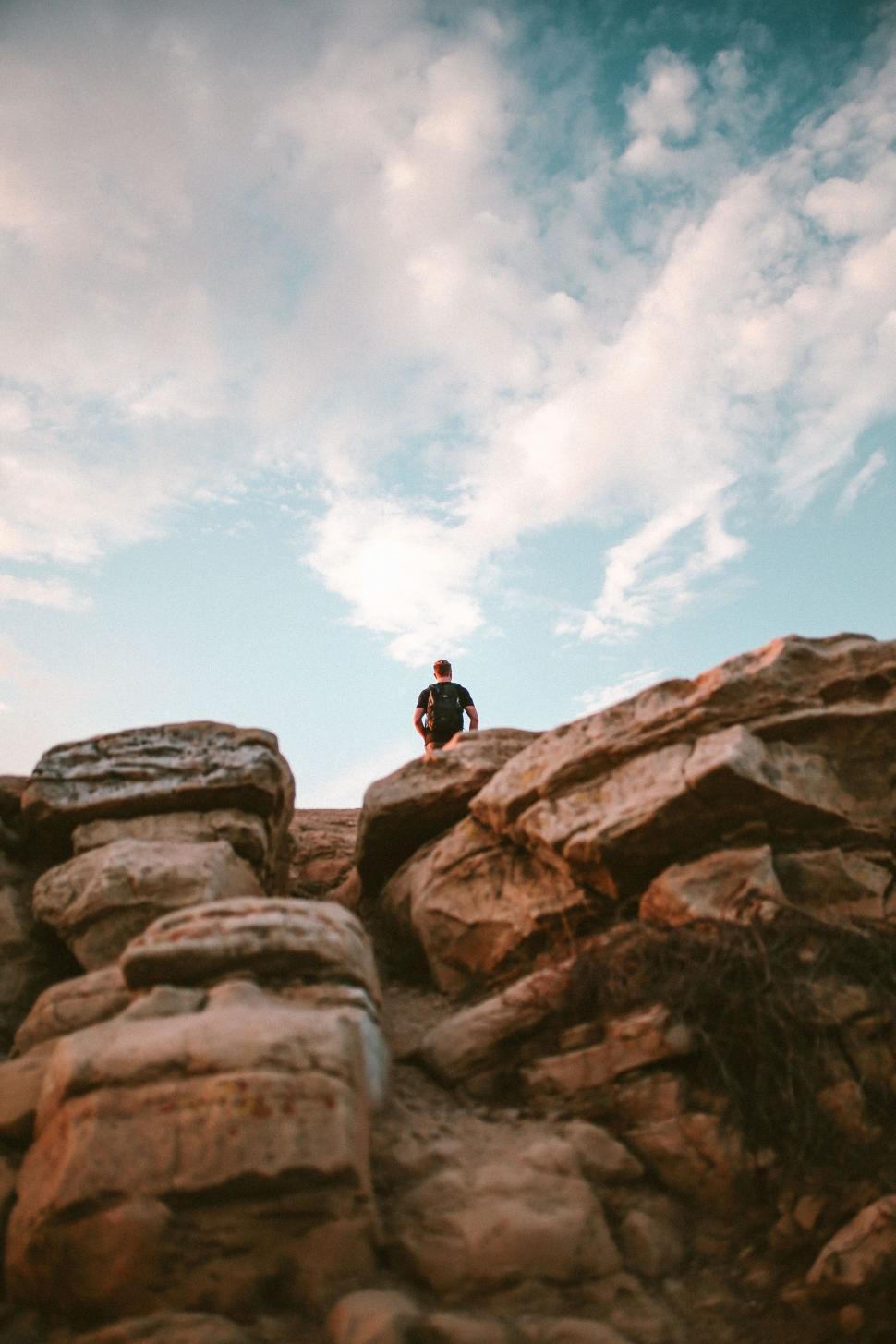 Free Image of Man Standing on Top of a Rocky Mountain 