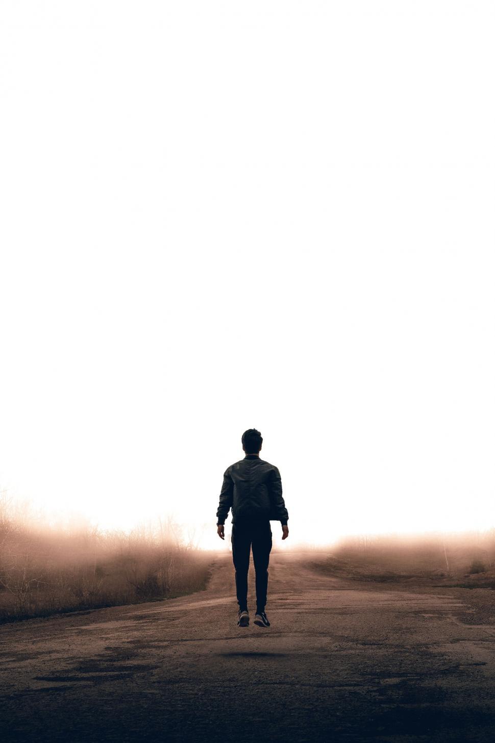 Free Image of Man Walking Down a Dirt Road 