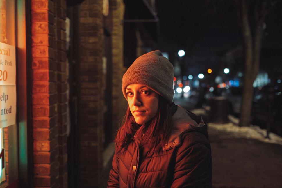 Free Image of Woman Standing in Front of Building at Night 