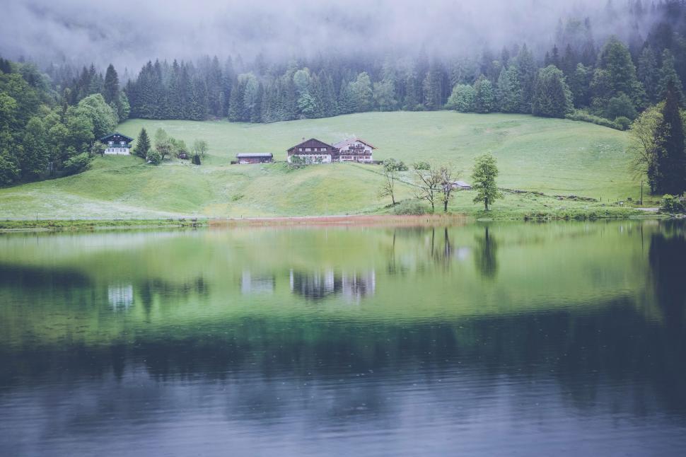 Free Image of Large Body of Water Surrounded by Lush Green Hillside 