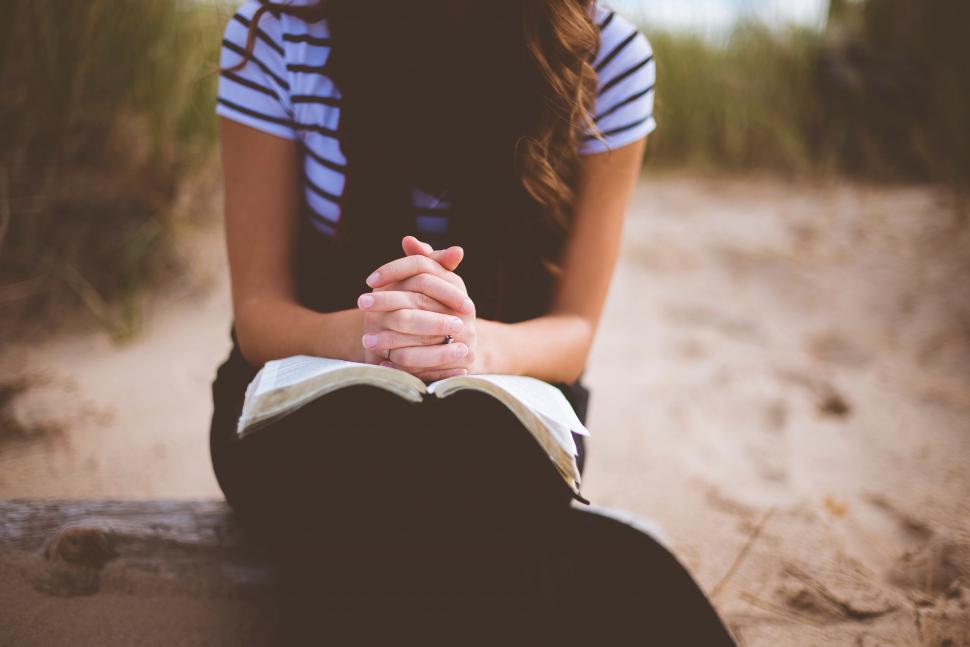Free Image of Woman Sitting on Bench With Folded Hands 