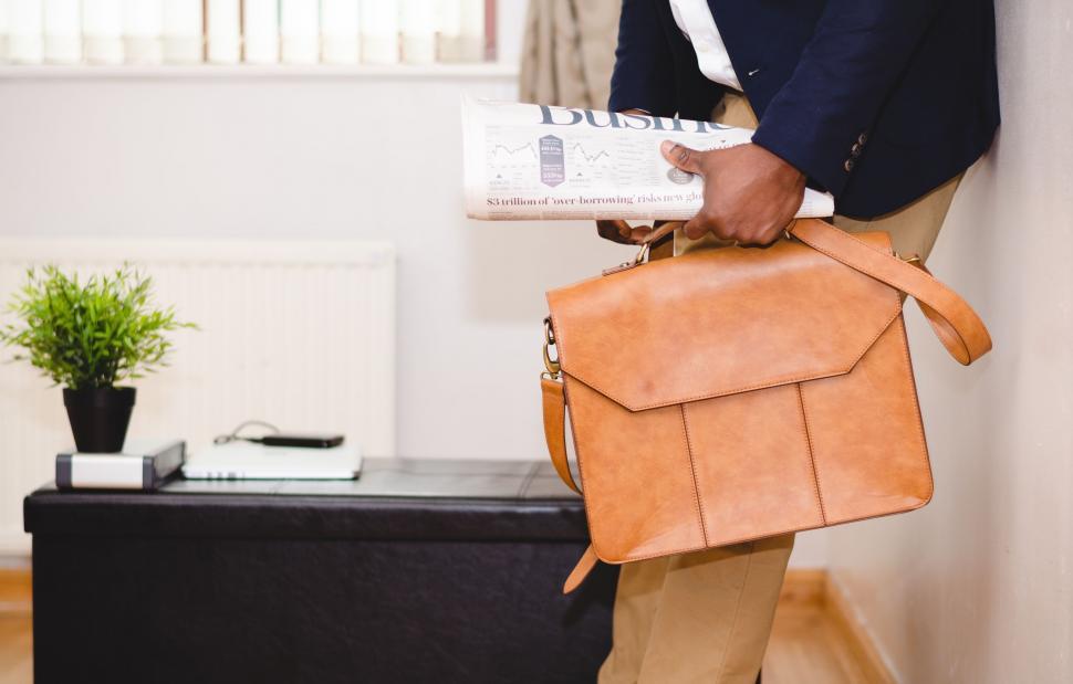 Free Image of Man in a Suit Holding a Brown Bag 
