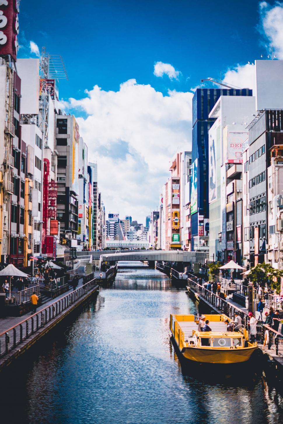 Free Image of River Running Through City Beside Tall Buildings 