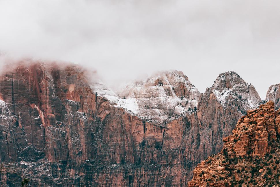 Free Image of Snow-Covered Mountain Range Amidst Clouds 