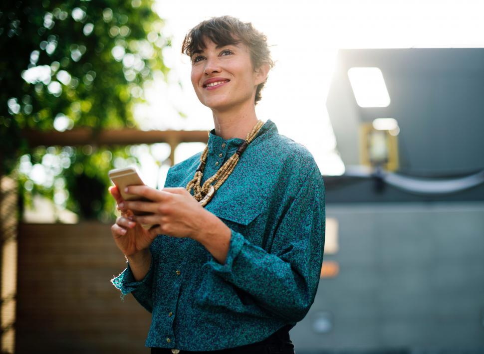 Free Image of Woman in Blue Shirt Holding Cell Phone 