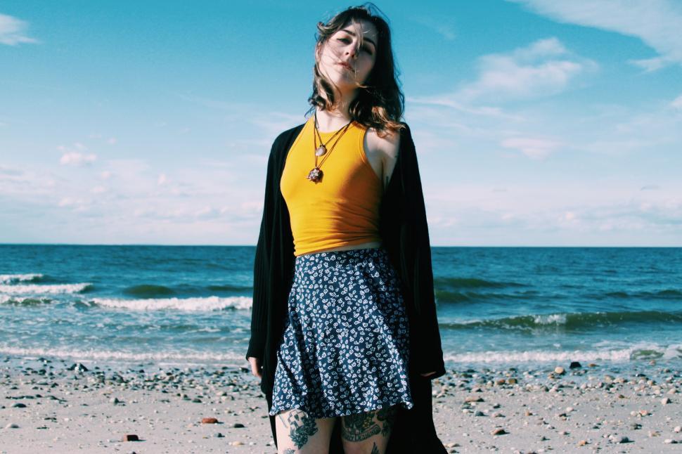 Free Image of Woman Standing on Top of Beach Near Ocean 