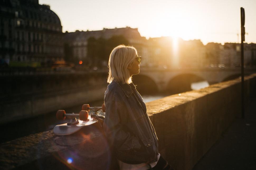 Free Image of Woman Standing on Bridge Looking at Sun 