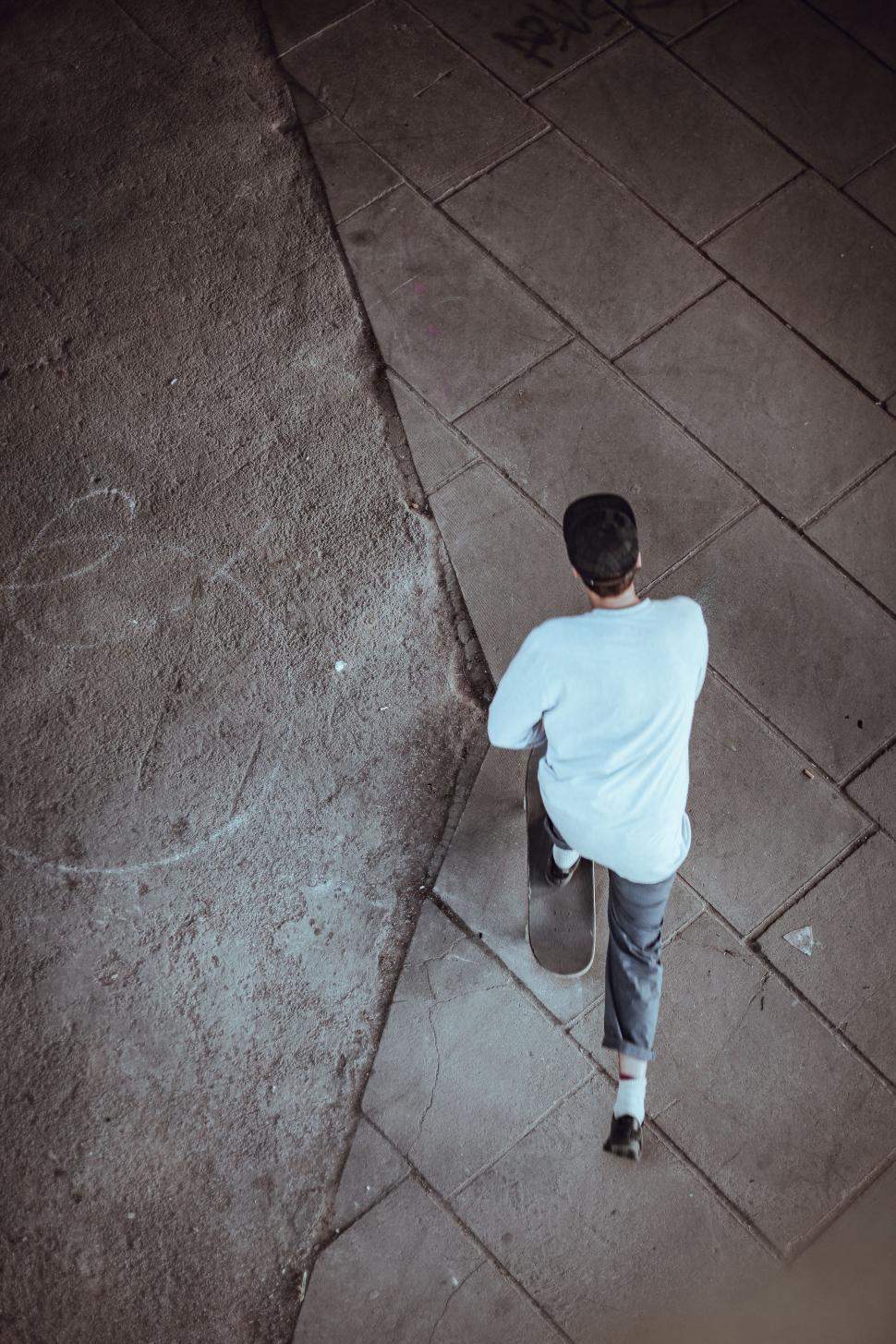 Free Image of Person Standing on Sidewalk With Skateboard 
