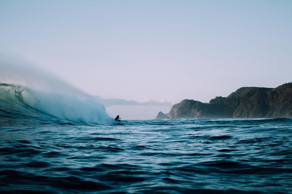 Free Image of Man Riding Wave on Surfboard 