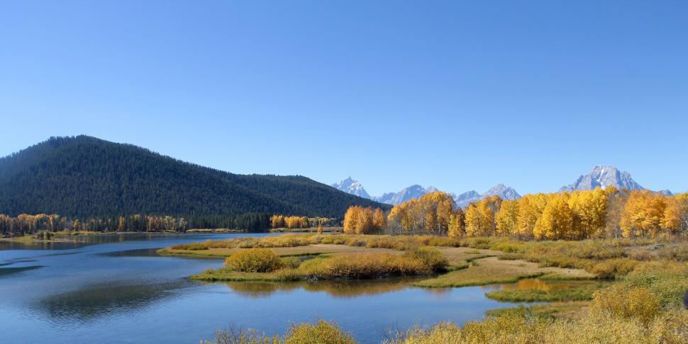 Free Image of Lake Surrounded by Trees With Mountains in Background 