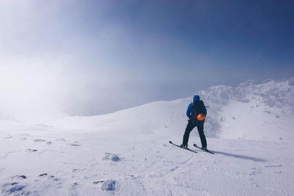 Free Image of Man Riding Snowboard Down Snow Covered Slope 