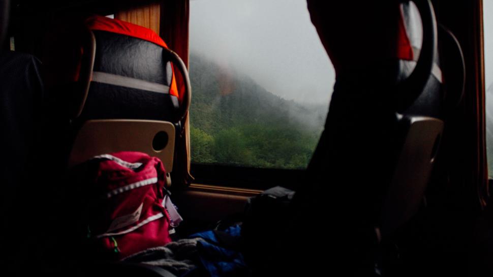 Free Image of Person Sitting on a Train Looking Out the Window 