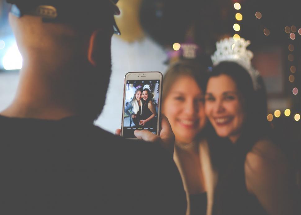 Free Image of Man Taking Picture of Woman With Cell Phone 