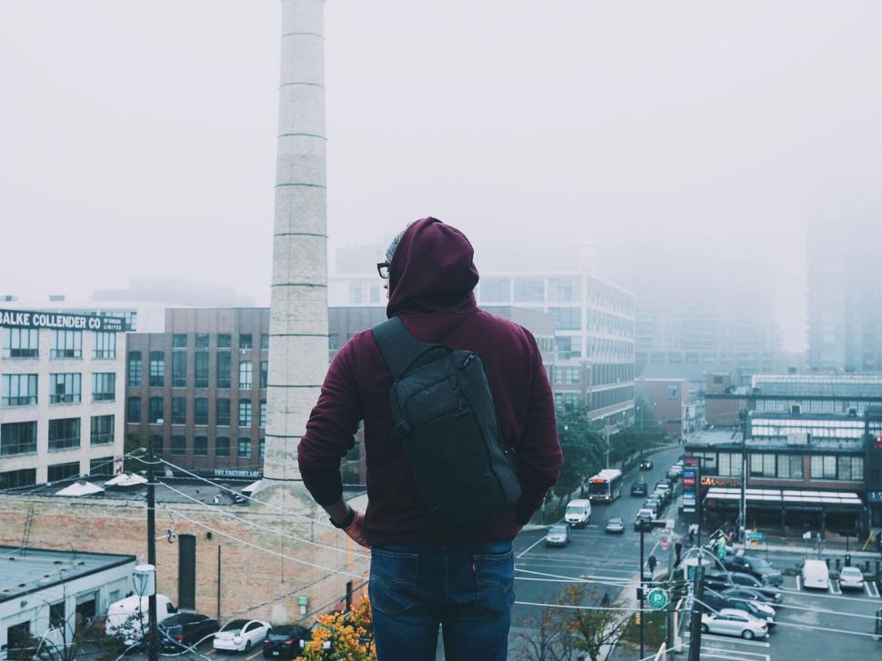 Free Image of Man With Backpack Standing on Top of Building 